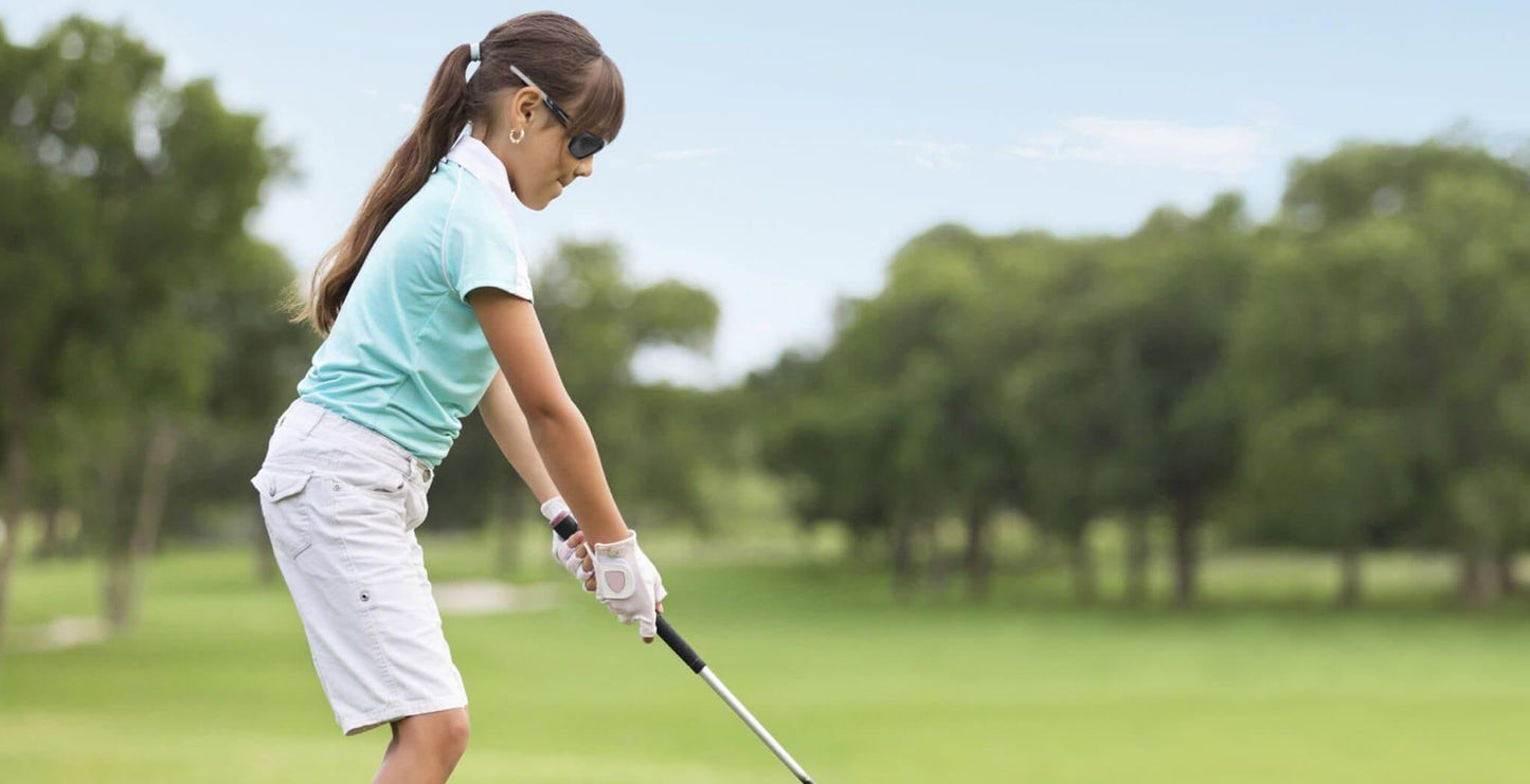 Young female golfer wearing PROGEAR Golf Prescription Sunglasses, demonstrating petite fit and secure grip during swing on golf course.