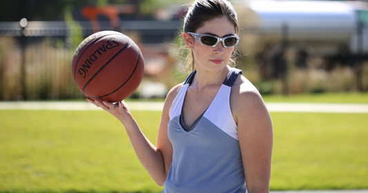 girl wearing sports glasses while playing basketball