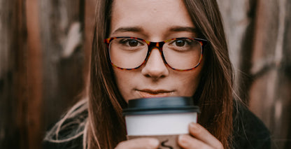 Woman wearing Free Form Eyewear™ Titanium 14g feather-light luxury German design glasses, tortoiseshell full frame, holding coffee cup.