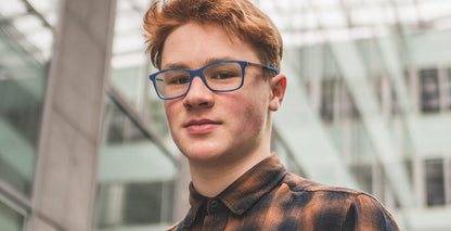 Model wearing Free Form Eyewear™ Titanium FFA994 in green full-rim frame. Lightweight 14g luxury German design eyeglasses for men and women.