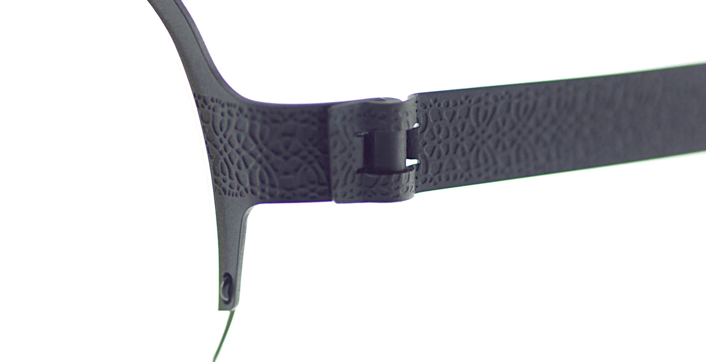 Close-up of Free Form Eyewear™ Titanium 14g feather-light eyeglasses, Model FFA937, showing screwless hinge and textured green half frame design.