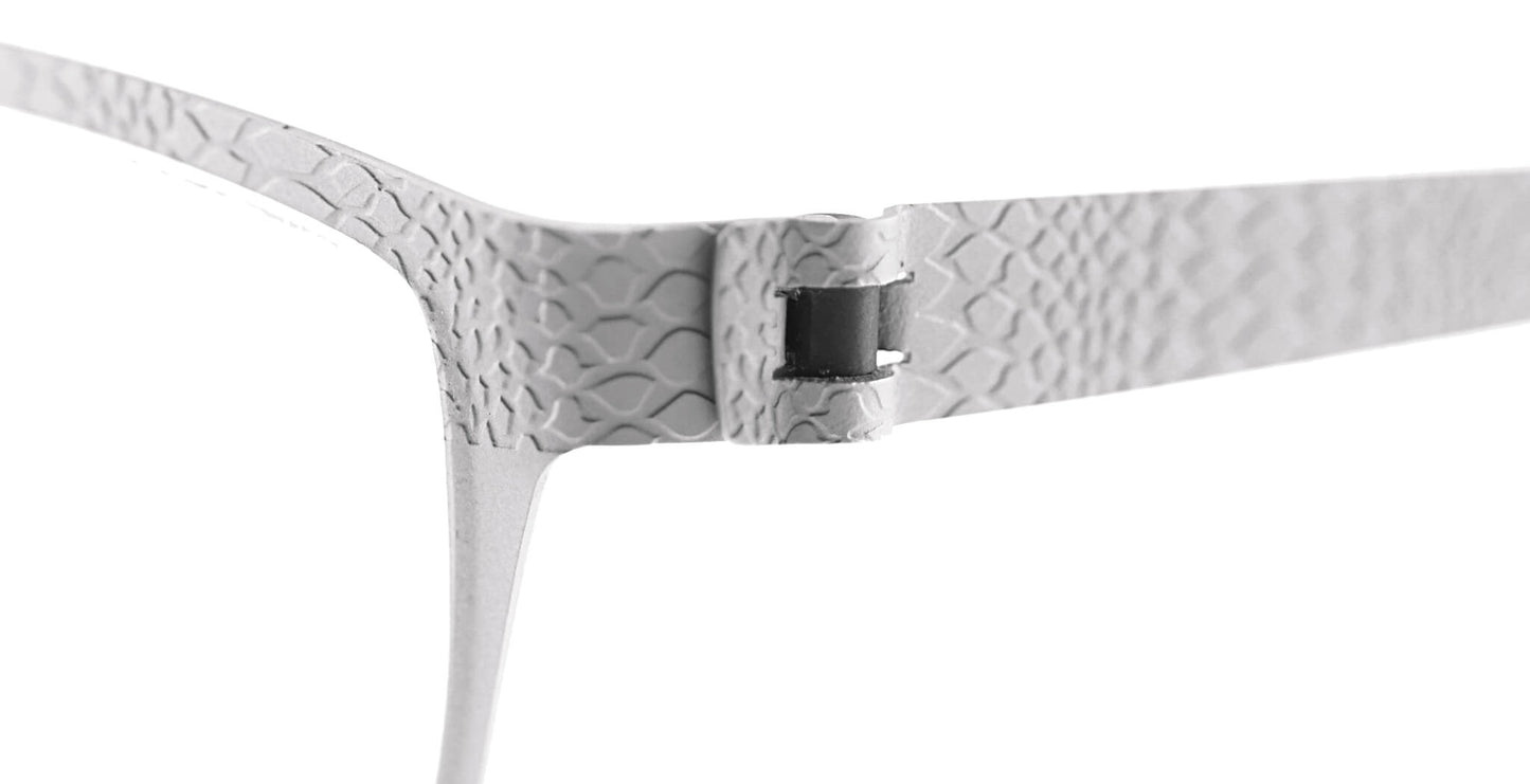 Close-up of Free Form Eyewear™ Titanium 14g feather-light eyeglasses hinge in textured silver finish. Features screwless German design for durability.
