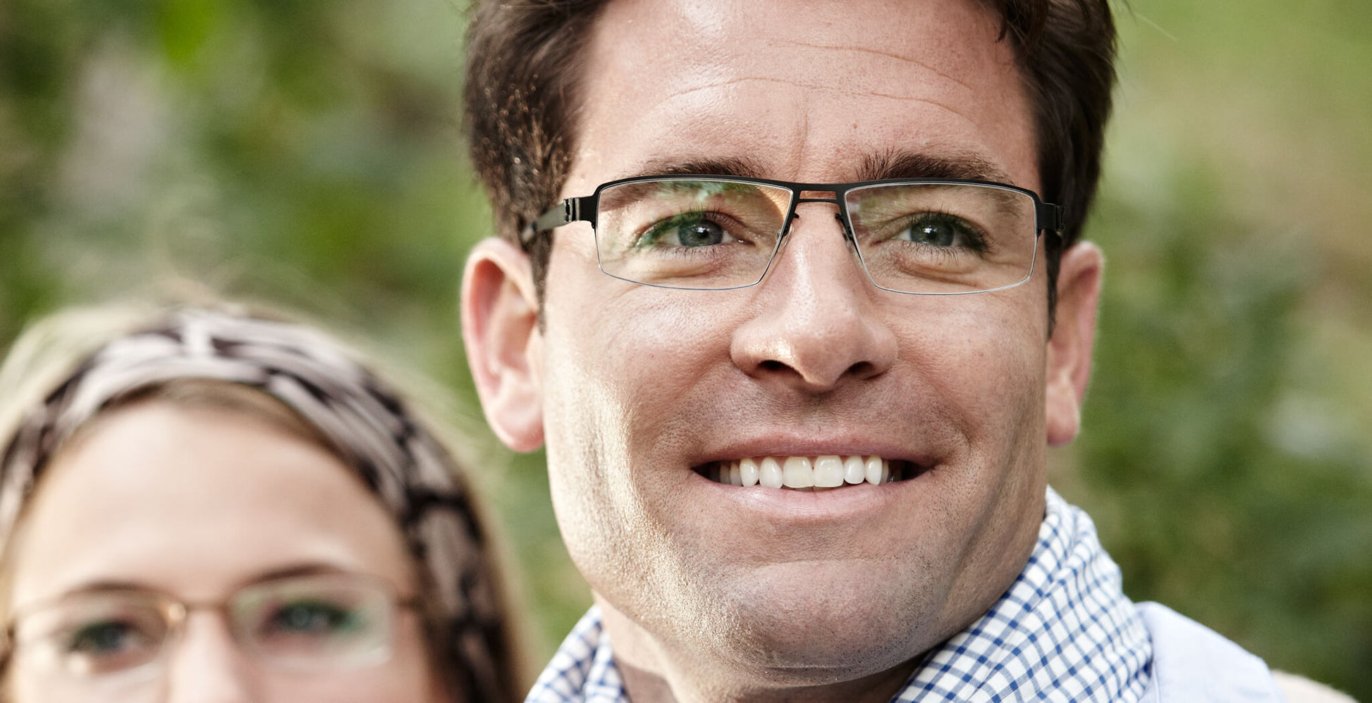Free Form Eyewear™ Titanium 14g feather-light eyeglasses in green half-frame design worn by a smiling man. Luxury German-engineered lightweight glasses for men.