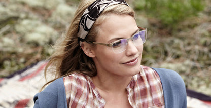 Free Form Eyewear™ Titanium 14g feather-light green half-frame glasses with blue light filter, worn by woman outdoors. Luxury German design for men and women.