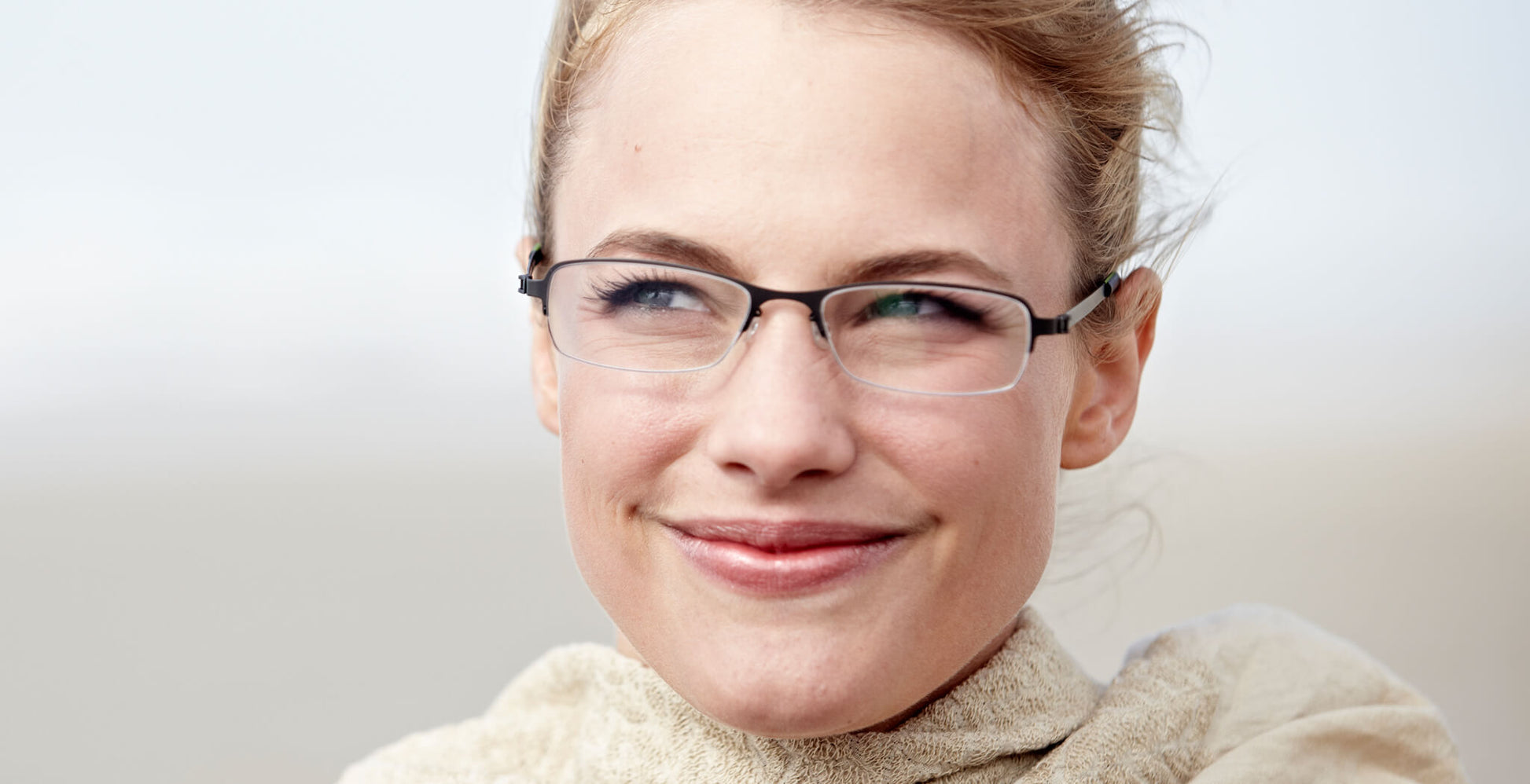 Free Form Eyewear™ Titanium 14g feather-light eyeglasses in green half-frame design, worn by woman outdoors. Luxury German design for men and women.