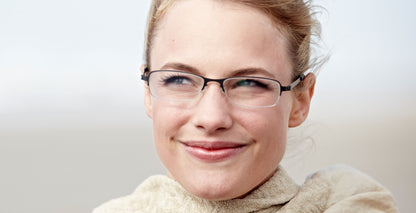 Free Form Eyewear™ Titanium 14g feather-light eyeglasses in green half-frame design, worn by woman outdoors. Luxury German design for men and women.