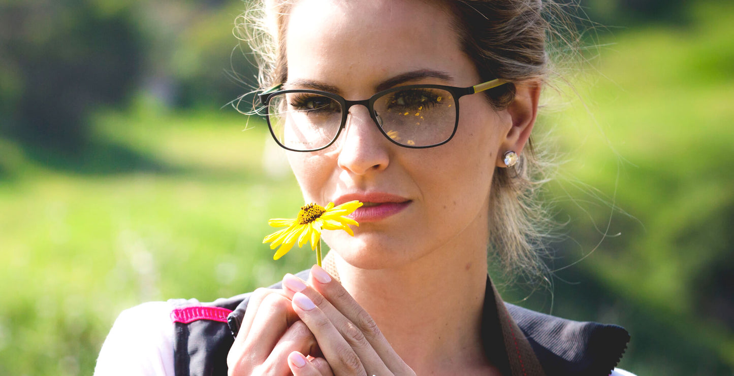 Free Form Eyewear™ Titanium 14g feather-light eyeglasses in green full frame worn by woman outdoors. Luxury German design for men and women.