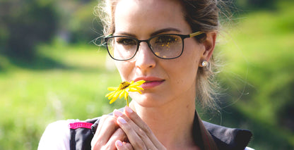 Free Form Eyewear™ Titanium 14g feather-light eyeglasses in green full frame worn by woman outdoors. Luxury German design for men and women.